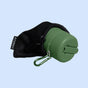 The TUSHY Travel Portable Bidet is a green, collapsible bottle with a carabiner, partially enclosed in a black mesh carrying pouch, displayed on a light blue background.