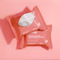 Two pink packs of Terra Hydrating and Cleansing Micellar Makeup Remover Wipes for Face & Eyes—Oily and Acne Prone Skin—on a pink background; one pack open with a white wipe partially pulled out.