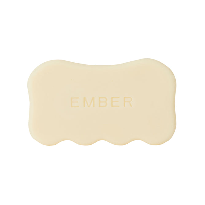The Body Serum Bar Set by Ember Wellness features a beige, scallop-edged soap bar embossed with "EMBER," designed for deep hydration, displayed against a white background.