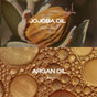 Close-up of a jojoba seed pod and golden oil bubbles highlight nourishing ingredients in The Face Starter Set by Ember Wellness, with brief text on their benefits for radiant, healthy skin.