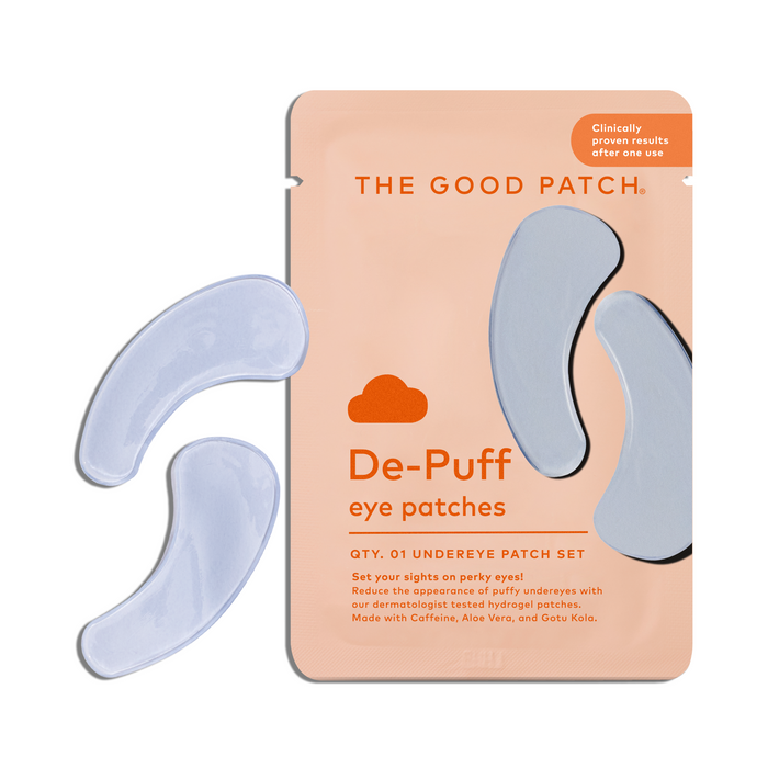 An orange packet labeled The Good Patch De-Puff Hydrogel Undereye Patch with two light blue crescent patches beside it. The packet notes one set and highlights de-puffing benefits to help reduce under-eye bags.