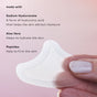 A hand holds The Good Patch Un-Frown Wrinkle Microdart Patch, a crescent-shaped, translucent patch for fine lines. Text highlights sodium hyaluronate (moisture), aloe vera (hydrates), and peptides (firms). Pink gradient background.