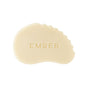 A smooth, cream-colored, curved stone tool engraved with EMBER and a scalloped edge—The Serum Bar by Ember Wellness—perfect for use with your favorite gua sha serum, displayed on a white background.