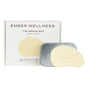 An open metal tin reveals Ember Wellness The Serum Bar—a beige, leaf-shaped solid face serum embossed with EMBER. This unscented vitamin C skincare product is perfect for use as a gua sha serum.