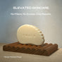 A uniquely shaped The Serum Bar by Ember Wellness, inspired by gua sha, rests on a ridged wooden dish. Above: ELEVATED SKINCARE. No Fillers, No Excess, Only Results. Small print: *Design Patented Shape.