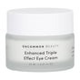 A frosted glass jar with a white lid labeled “Uncommon Beauty Enhanced Triple Effect Eye Cream” in black text, 20 ml (0.67 fl oz), featuring super ingredients for under-eye care.