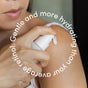 A person applies Uncommon Beauty Retinol Alternative from a white pump bottle to their shoulder. Curved text reads: Gentle and more hydrating than your average retinol alternative.