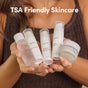 A person in a brown top holds the Uncommon Beauty Daily Skincare Travel Set, featuring five TSA-friendly essentials in clear bottles and a jar labeled with different formulas. Text above reads TSA Friendly Skincare.
