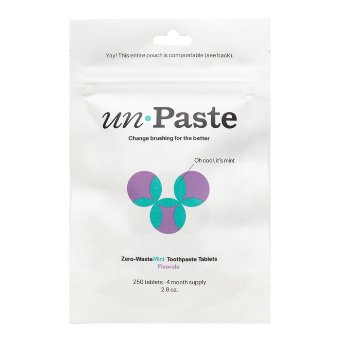 A white pouch of Unpaste Fluoride Mint Toothpaste Tablets features a geometric blue and purple design, highlights its plastic-free and compostable packaging, and offers a 4-month supply with 250 natural tablets.