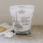 A bag of The Unscented Company Floor Cleaning Tabs - Unscented sits on a speckled countertop, with several white cleaning tablets in front. The white bag features black illustrations and bilingual English and French text.