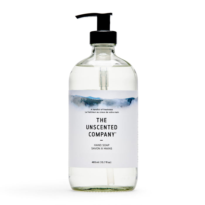 A clear pump bottle of The Unscented Company Hand Soap, with a minimalist label and mountain design, indicates it's unscented, vegan, and contains 465 mL (15.7 fl oz) of soap.