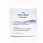 A white, plastic-free 65g box of The Unscented Company Shampoo Bar features minimalist blue mountain art and is fragrance free, with apricot and jojoba seed oil.