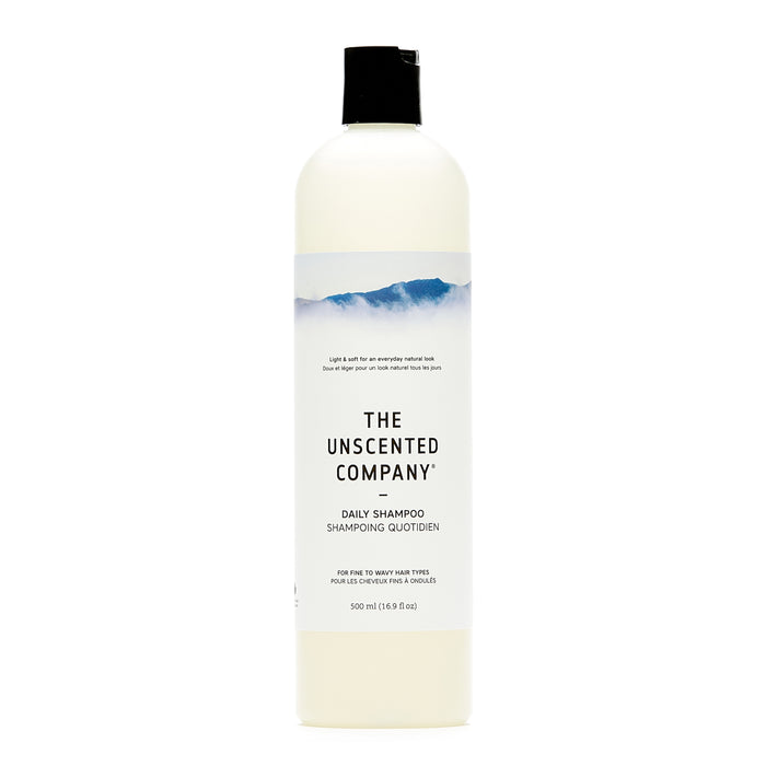 A 500 ml white bottle of The Unscented Company Daily Shampoo for fine to very fine hair, hypoallergenic, unscented, with a simple label and blue mountain design.
