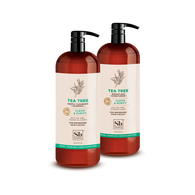 Two brown pump bottles labeled Tea Tree Shampoo & Conditioner 1 Liter Luxe from Soapbox are shown on a white background. The labels highlight their deep cleansing, vegan, color safe, and hard sulfate free formula for hair and scalp.