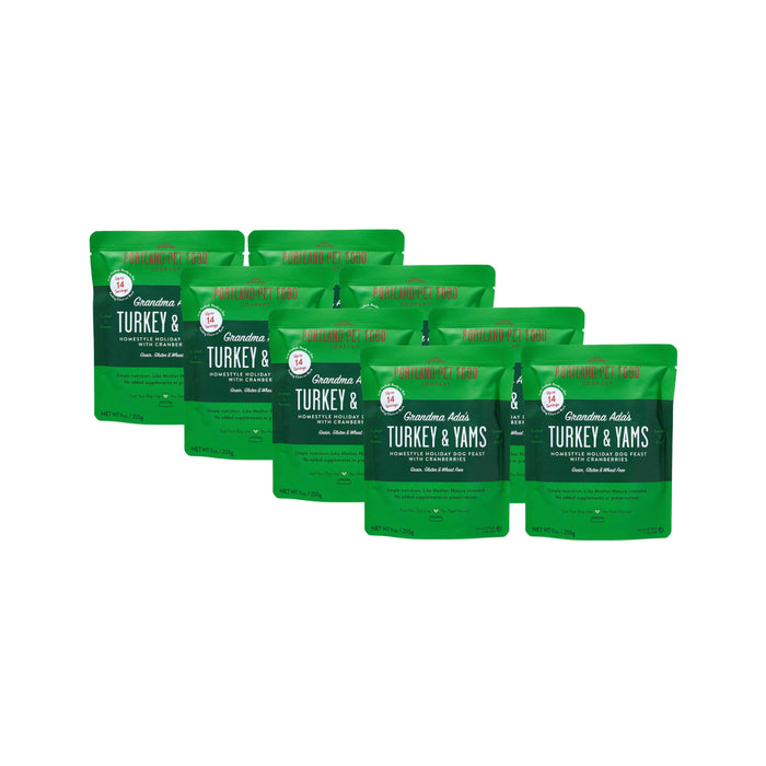 Six green 9 oz pouches of Portland Pet Food Company’s Grandma Adas Turkey & Yams Human-Grade Dog Meal are arranged in two rows against a white background.