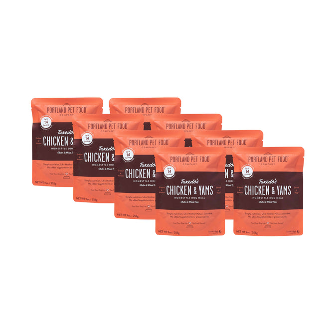 Six orange 9 oz pouches of Portland Pet Food Company’s Tuxedos Chicken & Yams Human-Grade Dog Meal are displayed in two rows, each showing the clear branding and product name. These meals use USA-sourced, human-grade ingredients.
