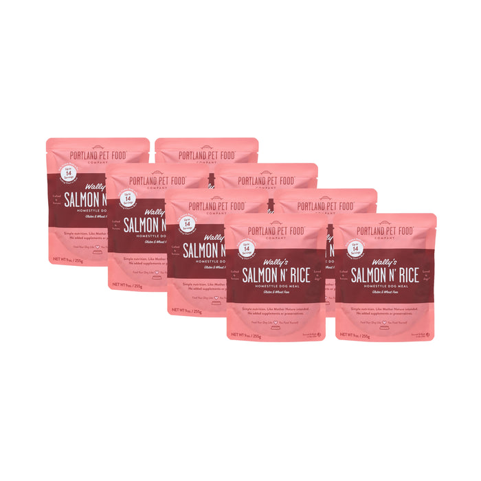 Six pouches of Portland Pet Food Companys Wallys Salmon N Rice Human-Grade Dog Meal (9 oz) are displayed in a staggered row on a white background, featuring white and dark red text on the packaging. Can be used as a meal or topper.