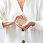 A person wears a white sweater and lathers the Little Seed Farm Milk (Unscented) Bar between their hands, creating white suds. The cropped image shows only hands, soap, and torso—ideal for sensitive skin users.