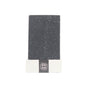 The Little Seed Farm Activated Charcoal Facial & Body Bar, a rectangular dark stone bar for sensitive or acne-prone skin, stands upright on a white base with a black band and snowflake pattern, set against a plain white background.