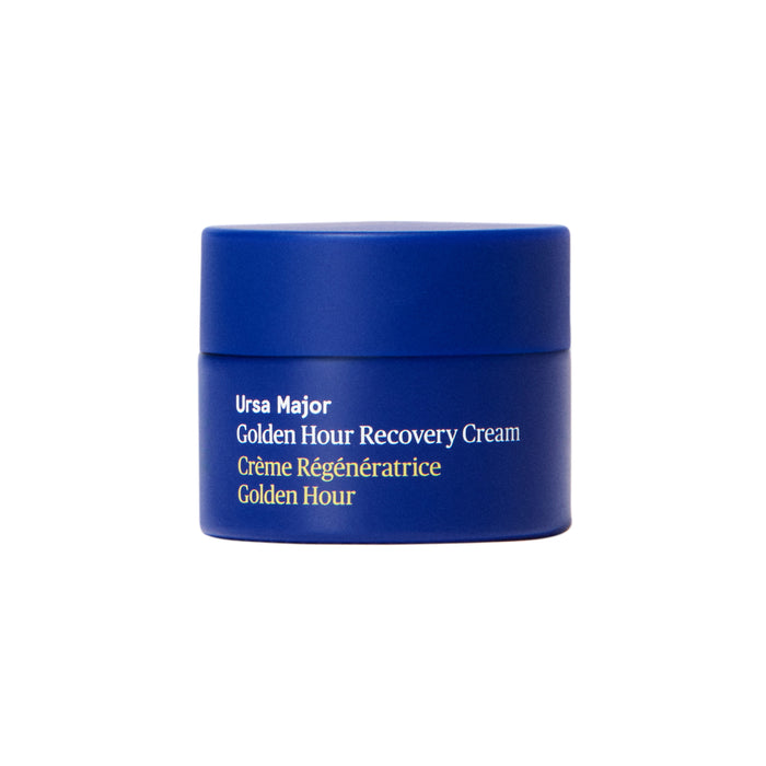 A blue jar of Ursa Major Golden Hour Recovery Cream, labeled “Crème Régénératrice Golden Hour,” is displayed against a white background, emphasizing its deep hydration benefits.