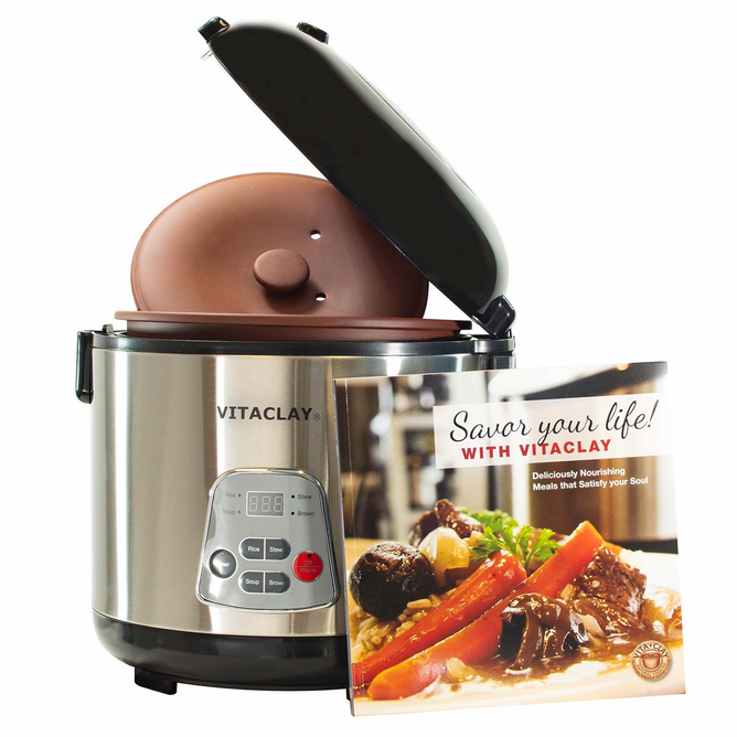 A stainless steel VitaClay® Chef 4-in-1 Organic Rice N’ Slow Cooker in Clay Pot (model VF7700) is shown with its lid open, displaying the inner clay pot that underlines its function as a premium rice cooker. In front of it sits a “Savor your life! with VitaClay” cookbook, featuring a plated meal on the cover.
