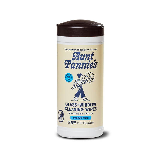 Aunt Fannie's Glass + Window Cleaning Wipes come in a beige-labeled container with blue text and a woman holding a cleaning tool. The label highlights 35 plant-based, vinegar-powered glass cleaner wipes.