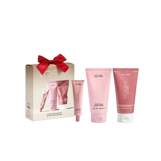 The VOESH Hand & Body Glow Set includes body balm, hand cream, and exfoliating body wash in three pink tubes, all beautifully packaged in a matching gift box with a red bow for radiant skin.