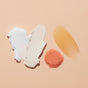 Four VOESH Pumpkin Pie Duo products on a peach background: creamy white vegan body cream, thick white lotion, loose pink granules, and a glossy amber gel scrub—all with an inviting autumn scent. Includes cute pumpkin nail stickers.