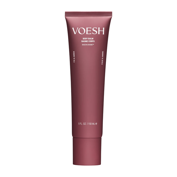 A maroon VOESH Body Balm tube with white text stands upright. The minimalistic 5 fl oz (150 mL) design contains hydrating body butter enriched with mango seed butter.