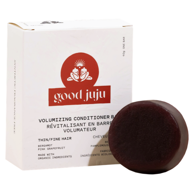 A dark round Volumizing Conditioner Bar - For Oily/Fine Hair from Good Juju Body & Home sits before a white box, highlighting bergamot, pink grapefruit, and organic ingredients for natural hair care.