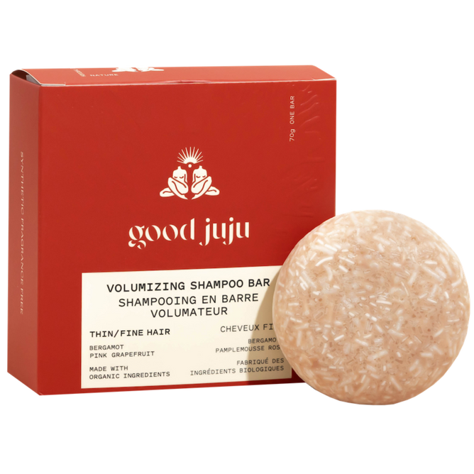 A round, beige Volumizing Shampoo Bar by Good Juju Body & Home sits before a red box. Made for oily/fine hair, it features bergamot and pink grapefruit to support natural hair growth.