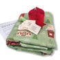 The Sew Your Own Set of 10 Gift Bags – Folk Art Cottages by Waste Free Celebrations includes festive green fabric, thread, labels, instructions, and red ribbon—ideal for your next reusable Christmas gift bag craft.