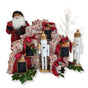 A festive display featuring a Santa Claus, white nutcracker figurines, a lit twig tree, and greenery with ornaments is enhanced by gifts in Waste Free Celebrations’ Set of 10 Reusable Gift Bags - Nutcracker Harlekin for sustainable wrapping.