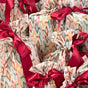 Set of 10 Reusable Gift Bags - Nutcracker Harlekin by Waste Free Celebrations feature colorful geometric patterns and bright red ribbon bows, offering a festive, elegant, and sustainable gift wrap alternative.