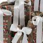 The Set of 5 Reusable Gift Bags - Pooches Christmas from Waste Free Celebrations features festive dog designs and white satin ribbon bows—a charming, eco-friendly alternative to traditional gift wrap.