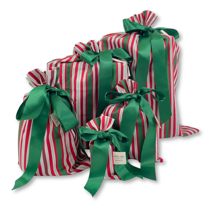 The Waste Free Celebrations Set of 5 Reusable Gift Bags—featuring red, white, and green stripes with green satin ribbons—offers a sustainable alternative to traditional wrapping.