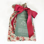 The Reusable Gift Bags - Desert Flower by Waste Free Celebrations are sustainably made in Afghanistan. Adorned with a red ribbon and green label, it includes five eco-friendly bags of varying sizes, offering a perfect sustainable gift wrap option.
