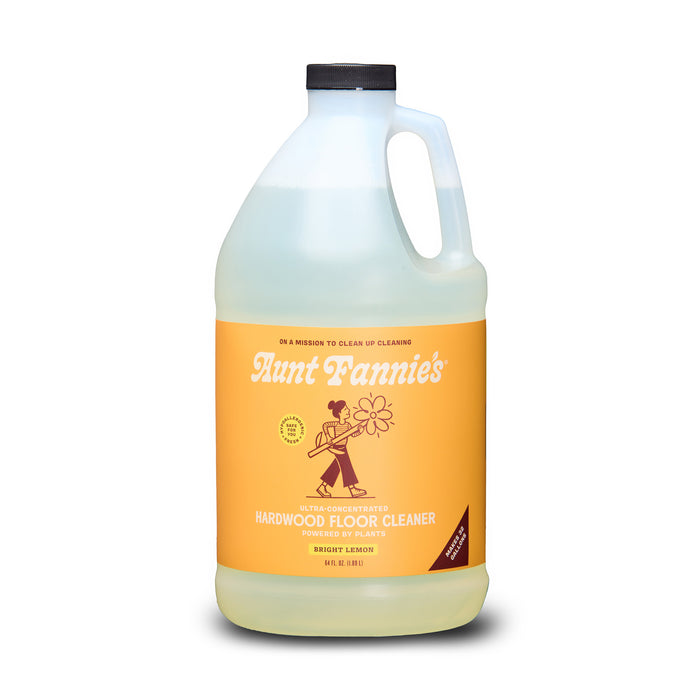 Aunt Fannie's Hardwood Floor Cleaner, Value Size, comes in a clear gallon jug with black cap and orange label featuring vintage-style design. This lemon-scented natural cleaner is made with essential oils.