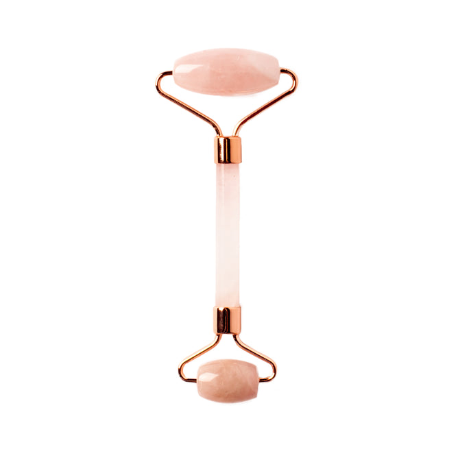The WTHN Face Roller Kit features two smooth, oval rose quartz stones and rose gold accents, designed to reduce puffiness with a beauty technique inspired by Traditional Chinese Medicine.