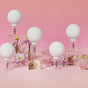WTHN Face Cupping Kit, inspired by Traditional Chinese Medicine, is displayed on clear blocks with pink and white flowers against a pink background.