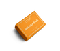 A rectangular orange Wonder Valley Hinoki Bar Soap, adorned with white leaf patterns and labeled “Hinoki Bar Soap/Savon,” rests on a white background.