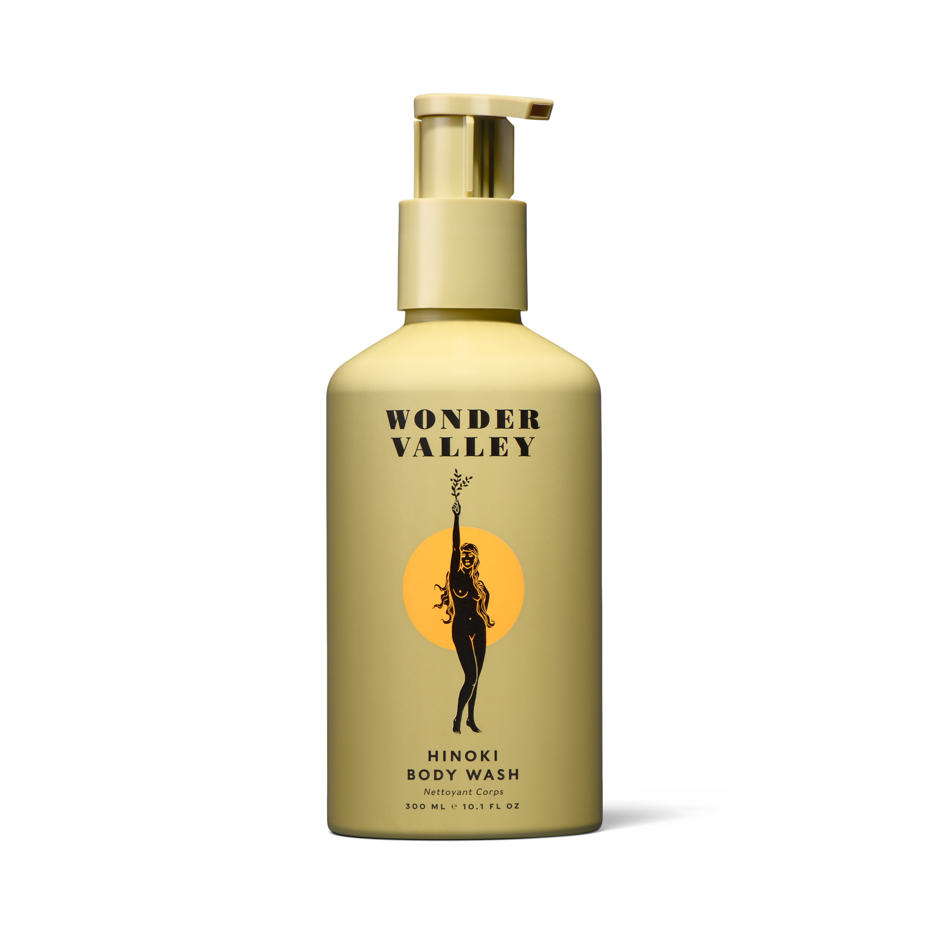 A beige bottle of Wonder Valley Hinoki Body Wash with a pump features a label showing a black silhouette of a woman holding an olive branch before an orange circle, reflecting its hinoki and cedar wood-inspired scent.