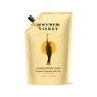 The beige Refill Sandalwood Yuzu Conditioner pouch by Wonder Valley features minimalist text, a black spout on the top left, and a black illustration of a woman holding a branch. The pouch contains a nourishing conditioner formula.