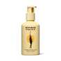 A yellow pump bottle of Wonder Valley Sandalwood Yuzu Conditioner features a black illustration of a woman with a branch before an orange circle. This nourishing formula helps reduce breakage and boost healthy shine.