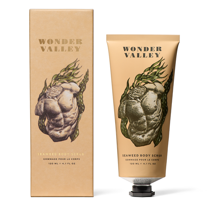 A beige tube and matching box of Wonder Valley Seaweed Body Scrub, adorned with a gold product name and an artistic torso entwined with seaweed, contains mineral clays and exfoliating sea salt for a refreshing cleanse.