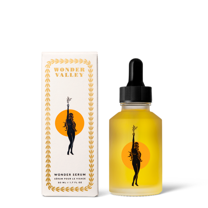 A bottle of Wonder Valley Wonder Serum with a black dropper cap sits by its box, both featuring a woman holding a branch before an orange circle, highlighting bioactive peptides and hyaluronic acid.