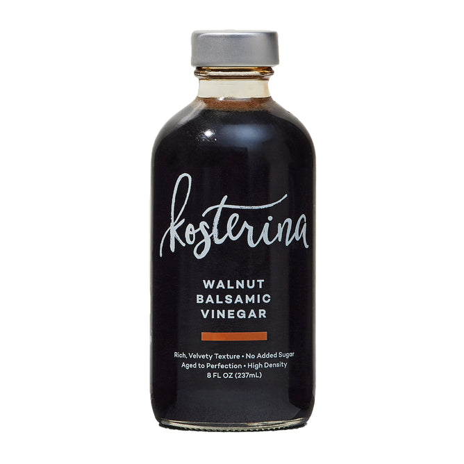 An 8 fl oz (237 mL) bottle of Kosterina Walnut Balsamic Vinegar from Modena, Italy, with a gray cap, dark liquid, and a label displaying the brand and product details in white and orange text.