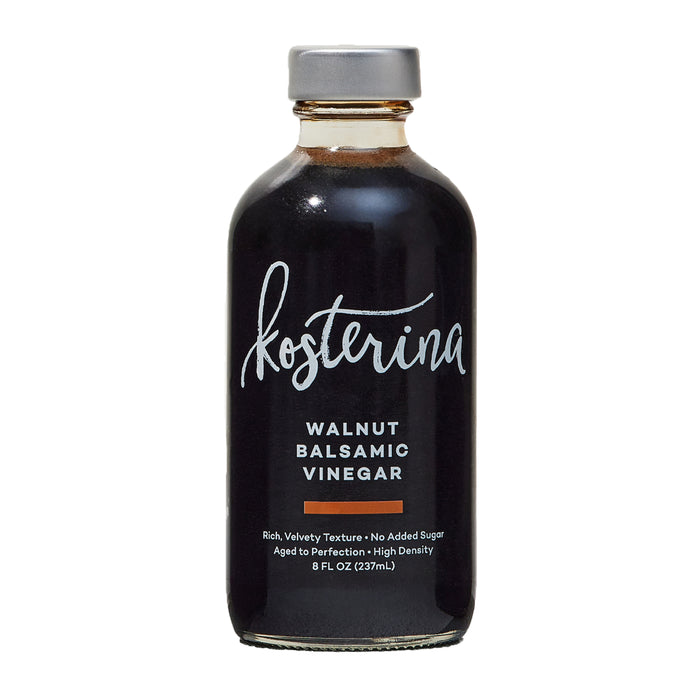 An 8 fl oz (237 mL) bottle of Kosterina Walnut Balsamic Vinegar from Modena, Italy, with a gray cap, dark liquid, and a label displaying the brand and product details in white and orange text.