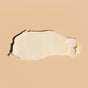 A smooth, creamy smear of Wildcraft Restore Face Cream - Sample with nourishing rosehip oils spread on a beige surface—ideal for relieving dry skin.