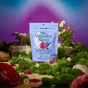 A bag of Plant People WonderSleep - Super Mushroom Gummies, a sleep aid without melatonin, stands upright on moss with scattered gummies, flowers, and plants against a dreamy, colorful gradient sky.